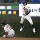 El dominicano José Ramírez, de los Guardianes de Cleveland, se barre en la intermedia sin que el torpedero de los Cachorros de Chicago, Dansby Swanson, a la derecha, logre controlar un lanzamiento del segunda base Nico Hoerner en la sexta entrada del partido en Chicago, el sábado 1 de julio de 2023. (AP Foto/Charles Rex Arbogast)