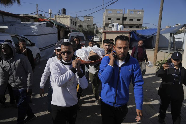 Dolientes cargan los cuerpos de palestinos muertos en el bombardeo de la Franja de Gaza para su entierro en Deir al-Balah, Franja de Gaza, el domingo 30 de marzo de 2025. (AP Foto/Abdel Kareem Hana)