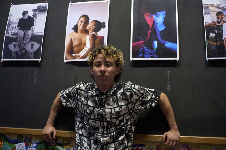 Merle Ramírez, un hombre transgénero, posa junto a sus retratos de cubanos transgénero en su exposición en la galería La Marca en La Habana, el viernes 4 de abril de 2025. (AP Foto/Ramón Espinosa)