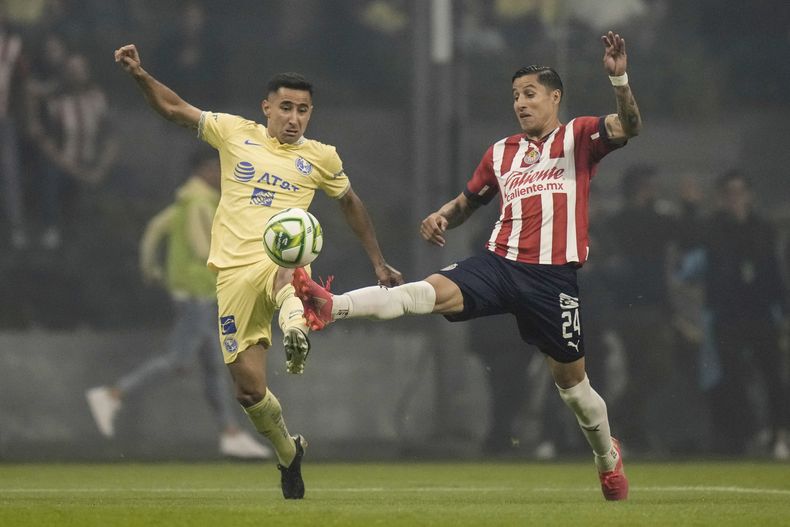 Luis Fuentes, del América, y Carlos Cisneros, del Guadalajara, se disputan un balón en el partido de vuelta de las semifinales del torneo mexicano, el domingo 21 de mayo de 2023, en la Ciudad de México. (AP Foto/Eduardo Verdugo)