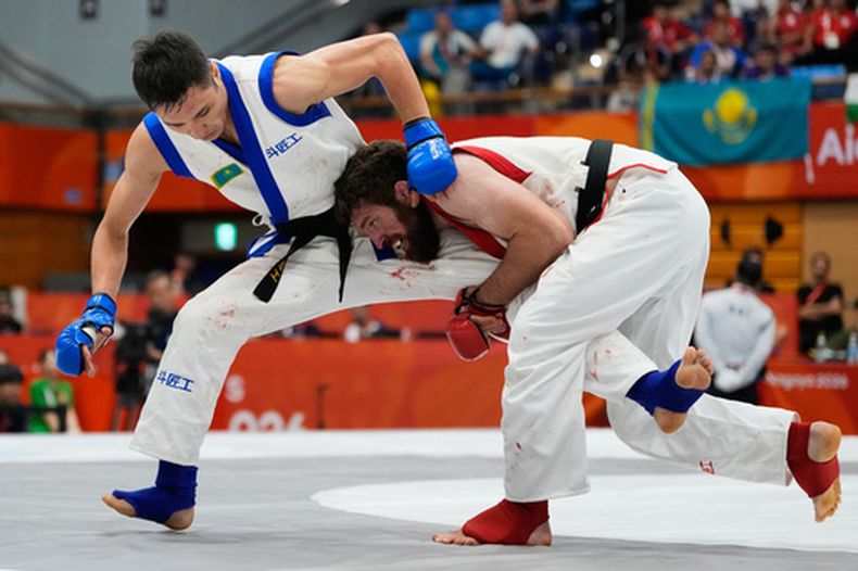 Mukhammad Nabiev de Bahrein pelea ante el kazajo Yerkingali Burkutalin en la categoría de 77 kilogramos de las artes marciales mixtas en los Juegos Asiáticos en Nagoya, Japón el martes 22 de septiembre del 2026. (AP Foto/Dita Alangkara)