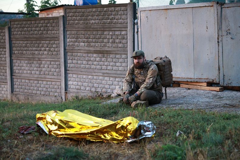 Un paramédico mira hacia el cadáver de una mujer muerta en un ataque ruso a un vecindario residencial en Zaporiyia, Ucrania, el 26 de septiembre de 2026. (AP Foto/Kateryna Klochko)