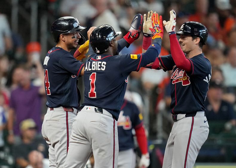 Mike Yastrzemski, derecha, de los Bravos de Atlanta, celebra su cuadrangular de tres carreras con Mauricio Dubon, izquierda, y Ozzie Albies, centro, durante la sexta entrada del juego de béisbol de Grandes Ligas contra los Astros de Houston, el domingo 20 de septiembre de 2026, en Houston. (AP Foto/Karen Warren)