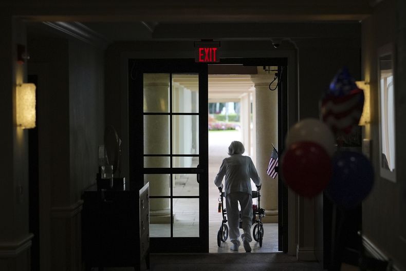 Una mujer usa una caminadora mientras sale de la residencia para ancianos Toby and Leon Cooperman Sinai Residences, el 4 de julio de 2025, en Boca Raton, Florida. (AP Foto/Rebecca Blackwell)