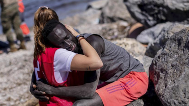 el abrazo que desato el odio y la solidaridad en espana: una voluntaria de cruz roja consuela a un migrante que acaba de llegar a ceuta