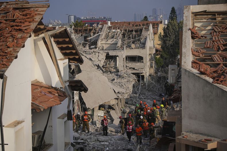 Efectivos de las fuerzas de seguridad israelíes inspeccionan un viviendas destruidas por un misil iraní, en Rishon Lezion, Israel, el 14 de junio de 2025. (AP Foto/Ohad Zwigenberg)