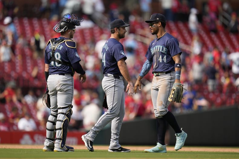 Julio Rodríguez (44) de los Marineros de Seattle celebra con JT Chargois (centro) y Mitch Garver tras la victoria ante los Cardenales de San Luis, el domingo 8 de septiembre de 2024, en San Luis. (AP Foto/Jeff Roberson)