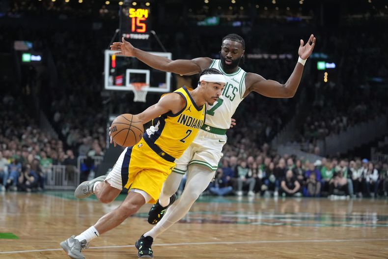 Andrew Nembhard (2), de los Pacers de Indiana, lleva el balón rumbo a la canasta frente a Jaylen Brown (7), de los Celtics de Boston, en la primera mitad del juego de baloncesto de la NBA, el domingo 29 de diciembre de 2024, en Boston. (AP Foto/Steven Senne)