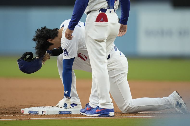 El bateador designado de los Dodgers de Los Ángeles, Shohei Ohtani (17), reacciona después de regresar a la primera base durante la primera entrada del juego de béisbol contra los Rojos de Cincinnati en Los Ángeles, el jueves 16 de mayo de 2024. (AP Foto/Ashley Landis)