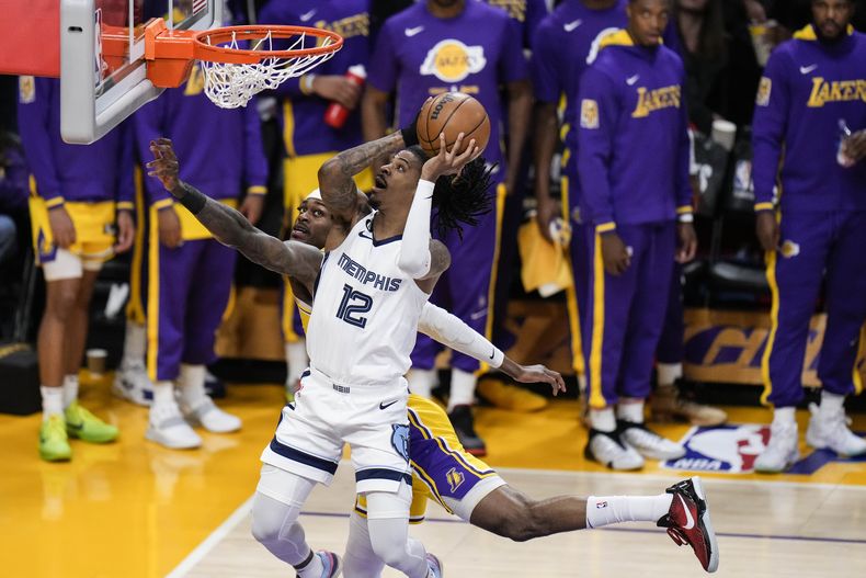 ARCHIVO - Ja Morant (12), de los Grizzlies de Memphis, ataca la canasta en contra de Jarred Vanderbilt, de los Lakers de Los Ángeles, durante la primera mitad del Juego 6 de la serie de primera ronda de playoffs de la NBA, el 28 de abril de 2023, en Los Ángeles. El coach de los Grizzlies, Taylor Jenkins, dice que Morant está presionando los botones correctos para prepararse lo mejor posible para regresar de su suspensión de 25 partidos a mediados de diciembre. (AP Foto/Jae C. Hong, Archivo)