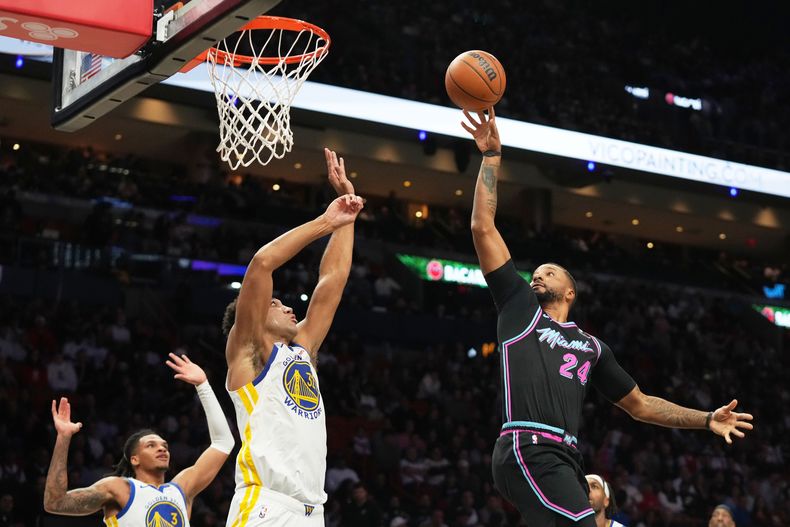 Norman Powell, base del Heat de Miami, salta a la cesta, frente al alero Trayce Jackson-Davis, de los Warriors de Golden State, el miércoles 19 de noviembre de 2025 (AP Foto/Lynne Sladky)