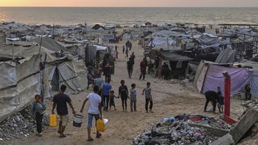 Palestinos desplazados caminan por un campamento improvisado en la playa de Ciudad de Gaza, el domingo 10 de agosto de 2025. (AP Foto/Jehad Alshrafi)