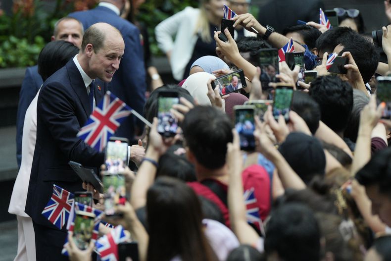 El príncipe Guillermo de Gales, izquierda, es recibido por una multitud a su llegada al Aeropuerto Jewel Changi de Singapur, el domingo 5 de noviembre de 2023. (AP Foto/Vincent Thian)
