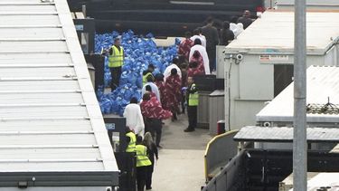 Un grupo de personas, al parecer migrantes, en la instalación de la fuerza de fronteras británica en Dover, Inglaterra, el 1 de junio del 2025, tras varios cruces de botes por el Canal de la Mancha. (Gareth Fuller/PA via AP)
