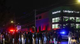Personas se reúnen afuera de un almacén donde se encontró muerto a un sospechoso del tiroteo en la Universidad de Brown, el jueves 18 de diciembre de 2025, en Salem, Nueva Hampshire. (Foto AP/Reba Saldanha)