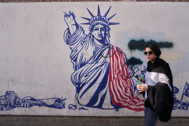 Una mujer pasa junto a un mural antiestadounidense en la pared de la antigua embajada de Estados Unidos, ahora convertida en museo, en Teherán, Irán, el viernes 12 de junio de 2026. (Foto AP/Vahid Salemi)