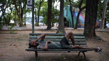Un hombre que lava automóviles descansa sobre una banca en la plaza Uruguay durante una tarde cálida, el viernes 17 de enero de 2025, en Asunción, Paraguay. (AP Foto/Jorge Saenz)