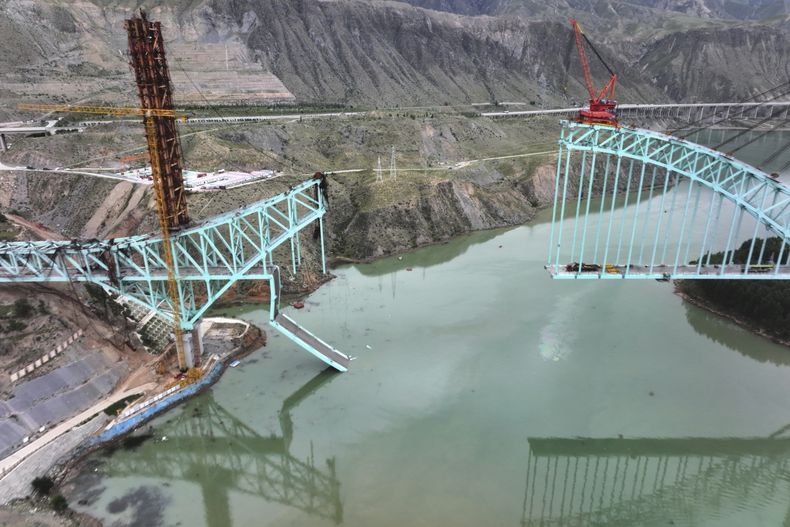 Esta imagen aérea, distribuida por la agencia noticiosa estatal Xinhua, muestra el lugar donde se derrumbó un puente en construcción en un tramo de la vía ferroviaria Sichuan-Qinghai, que dejó varios muertos y desaparecidos, en la provincia de Qinghai, en el noroeste de China, el 22 de agosto de 2025. (Li Zhanyi/Xinhua vía AP)