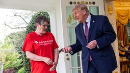 Sharon Simmons, repartidora de DoorDash, recibe una propina de 100 dólares después de llevarle un pedido de McDonalds al presidente Donald Trump en el Despacho Oval de la Casa Blanca, el lunes 13 de abril de 2026, en Washington. (AP Foto/Alex Brandon)