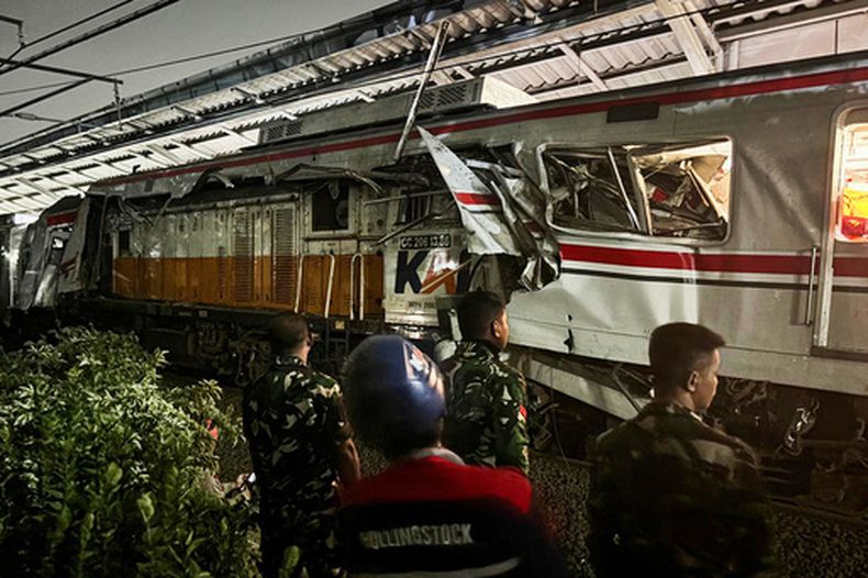 Soldados del Ejército de Indonesia examinan los daños después de un choque de tren, el martes 28 de abril de 2026, en Bekasi, Indonesia. (AP Foto/Fadlan Syam)