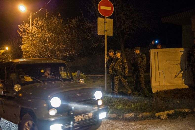Integrantes de las llamadas fuerzas de autodefensa de Crimea esperan afuera del centro de entrenamiento de las fuerzas navales de Ucrania que ocuparon en Sebastopol, el mi&eacute;rcoles 19 de marzo de 2014. (Foto de AP/Andrew Lubimov)