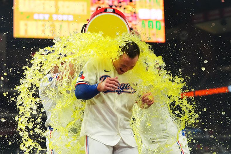 Wyatt Langford, de los Rangers de Texas, es bañado tras conectar el sencillo de la victoria en la novena entrada de un partido de béisbol contra los Angelinos de Los Ángeles, el jueves 9 de julio de 2026, en Arlington, Texas. (Foto AP/LM Otero)