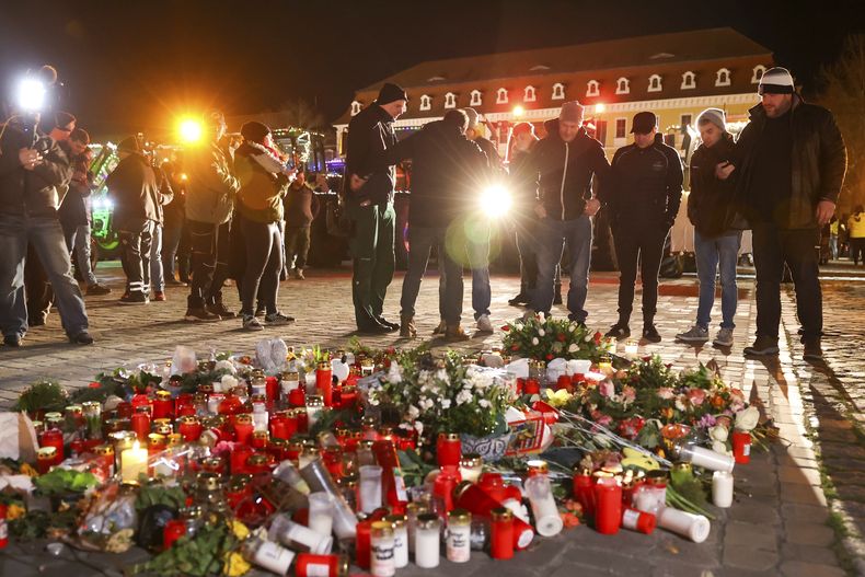Varias personas depositan flores en la plaza de la catedral de Magdeburgo, Alemania, el miércoles 1 de enero de 2025, en recuerdo de las víctimas del atentado perpetrado en un mercado navideño el 20 de diciembre de 2024. (Peter Gercke/dpa via AP)