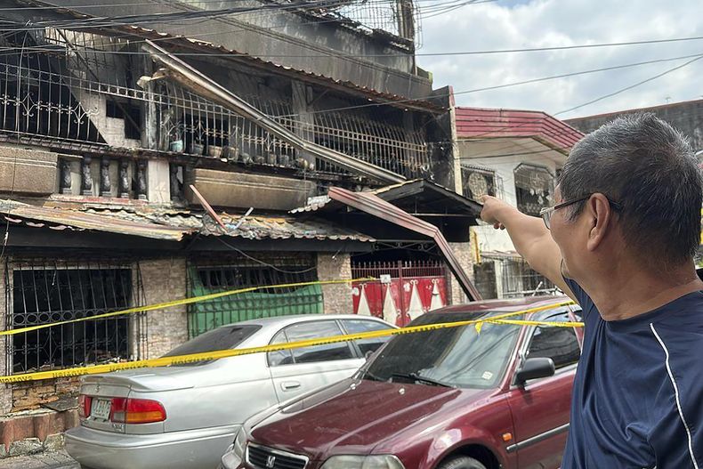 Alberto Masakay, vecino de la zona, señala a la segunda planta de un edificio en San Isidro Galas, un suburbio de Quezon, Filipinas, tras un incendio el jueves 27 de febrero de 2025. (AP foto/Joeal Calupitan)
