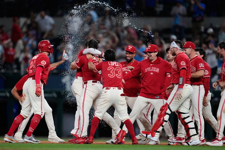 Los Rangers de Texas festejan el hit del dominicano Ezequiel Durán, que puso fin al duelo ante los Angelinos de Los Ángeles en la décima entrada, el viernes 21 de agosto de 2026 (AP Foto/Tony Gutiérrez)