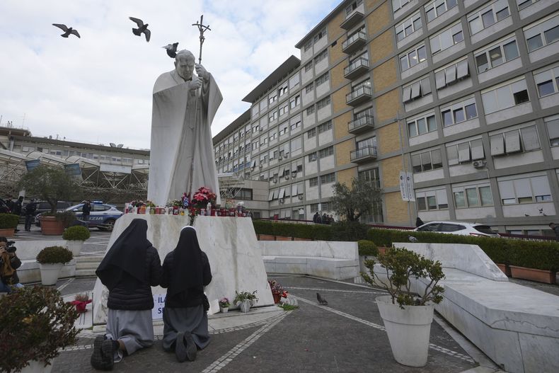 Dos monjas rezan frente a una estatua de san Juan Pablo II frente al hospital policlínico Agostino Gemelli, en Roma, el 20 de febrero de 2025, donde el papa Francisco está hospitalizado desde la semana pasada. (AP Foto/Alessandra Tarantino)