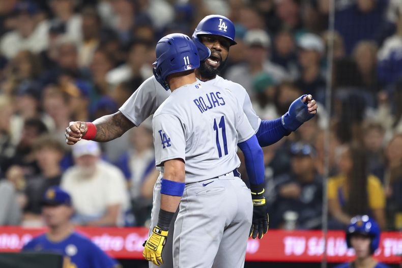 El venezolano Miguel Rojas, de los Dodgers de Los Ángeles, festeja con Jason Heyward, luego de batear un jonrón de dos carreras en el juego del viernes 15 de septiembre de 2023, ante los Marineros de Seattle (AP Foto/Maddy Grassy)