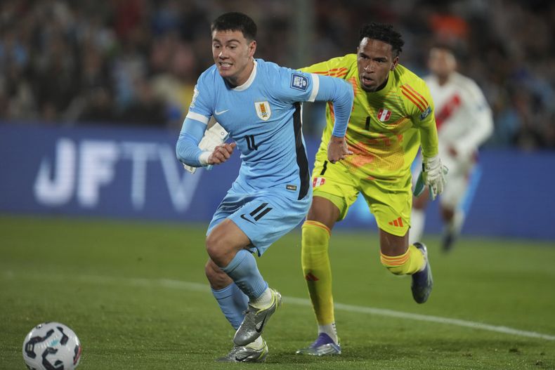 Facundo Pellistri, de la selección de Uruguay, controla el balón, perseguido por el arquero peruano Pedro Gallese, en un partido de las eliminatorias al Mundial, el jueves 4 de septiembre de 2025, en Montevideo (AP Foto/Matilde Campodonico)