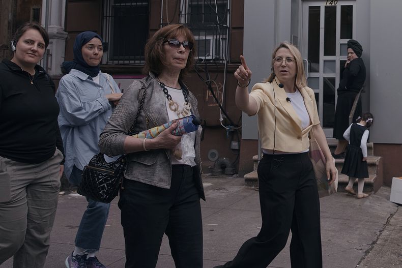 Frieda Vizel, derecha, guía a los participantes durante su recorrido a pie por la zona jasídica de Williamsburg, en el barrio de Brooklyn, Nueva York, el lunes 16 de junio de 2025. (AP Foto/Andres Kudacki)