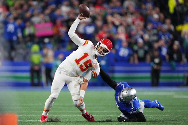El quarterback Patrick Mahomes de los Chiefs de Kansas City intenta soltar el balón ante el asedio del linebacker Uchenna Nwosu (7) de los Seahawks de Seattle, el domingo 25 de octubre de 2026, en Seattle. (AP Foto/Lindsey Wasson)