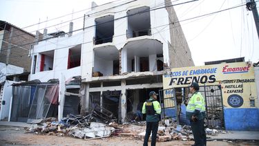 La policía permanece afuera de un edificio dañado por una explosión en Trujillo, Perú, el viernes 14 de agosto de 2025. (AP Foto/Gabriel Romero)