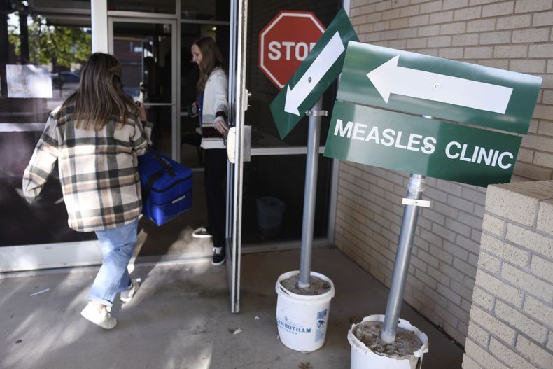 ARCHIVO - Miembros del personal del Departamento de Salud del condado de Andrews llevan dosis de la vacuna contra el sarampión, las paperas y la rubeola, el martes 8 de abril de 2025, en Andrews, Texas. (AP Foto/Annie Rice, Archivo)
