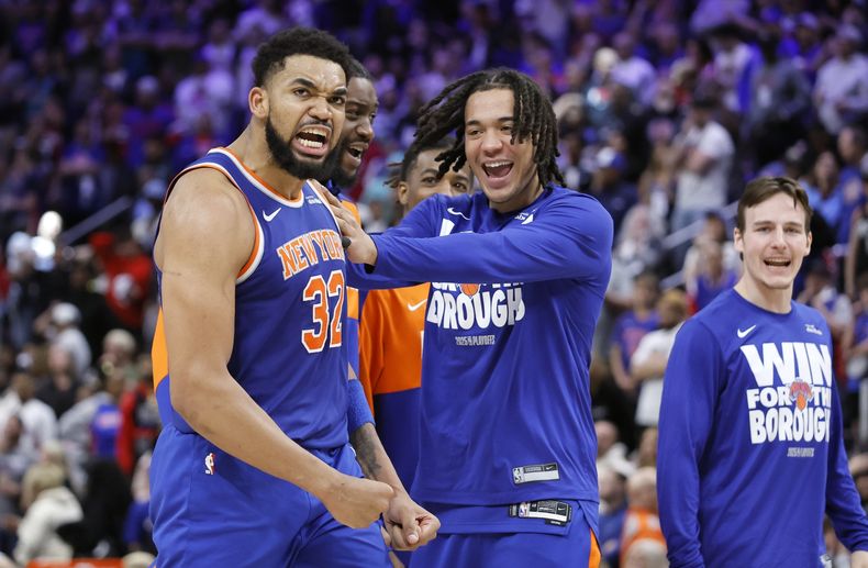 El escolta de los Knicks de Nueva York, Pacome Dadiet, en el centro, celebra con el pívot Karl-Anthony Towns (32) al final del último cuarto de su victoria sobre los Pistons de Detroit en el Juego 4 de una serie de playoffs de primera ronda de baloncesto de la NBA, el domingo 27 de abril de 2025, en Detroit. (AP Foto/Duane Burleson)