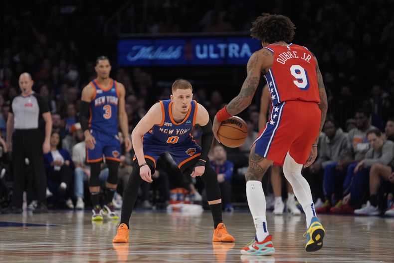 Kelly Oubre Jr. (9), de los 76ers de Filadelfia, es defendido por Donte DiVincenzo (0), de los Knicks de Nueva York, durante la segunda mitad del juego de baloncesto de la NBA, en Nueva York, el domingo 10 de marzo de 2024. (AP Foto/Peter K. Afriyie)