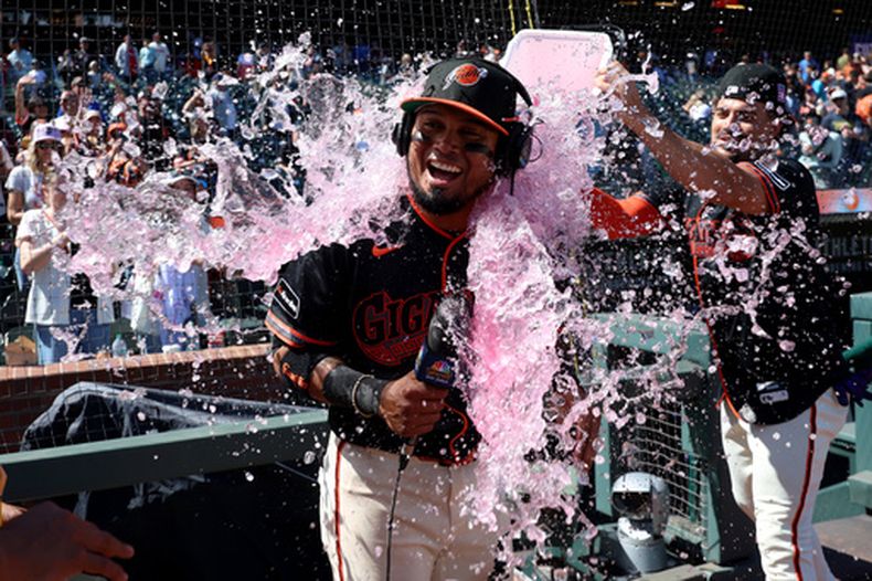 Luis Arráez, de los Gigantes de San Francisco, es empapado por el dominicano Willy Adames, tras la victoria sobre los Angelinos de Los Ángeles, el sábado 25 de julio de 2026. (AP Foto/Jed Jacobsohn)