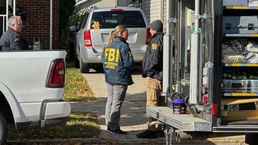 Agentes del FBI se reúnen frente a una casa en un vecindario de Dearborn, Michigan, el viernes 31 de octubre de 2025. (Foto AP/Mike Householder)
