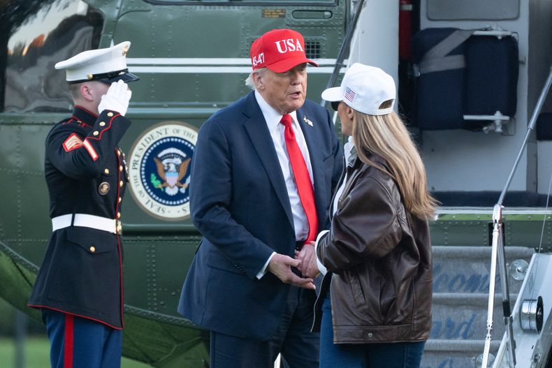 El presidente Donald Trump habla con la primera dama Melania Trump luego de que ambos descendieron del helicóptero Marine One a su llegada a la Casa Blanca, el domingo 5 de octubre de 2025, en Washington. (AP Foto/Manuel Balce Ceneta)