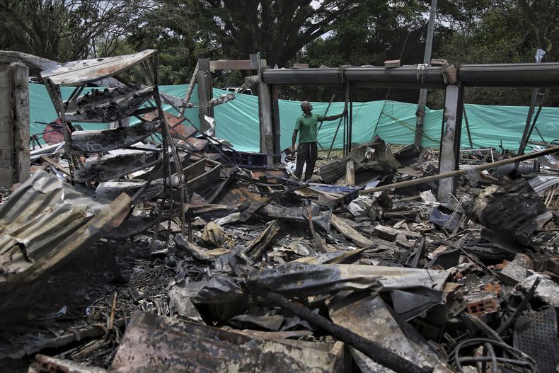 Un trabajador se encuentra en lo que queda de un almacén de repuestos después de que un coche bomba explotara detrás de una comisaría en Timba, Cauca, Colombia, el miércoles 20 de septiembre de 2023. (AP Foto/Andrés Quintero)