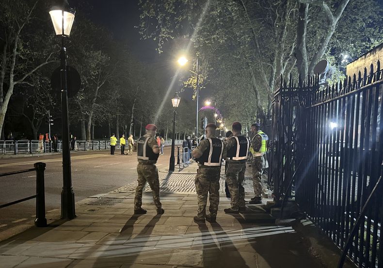 Agentes de la policía resguardan una zona a las afueras del Palacio de Buckingham, en Londres, el martes 2 de mayo de 2023, luego de que un hombre fue arrestado después de que se acercó a las puertas del palacio y arrojado objetos que se sospecha eran cargadores de escopeta. (Ben Roberts-Haslam/PA vía AP)