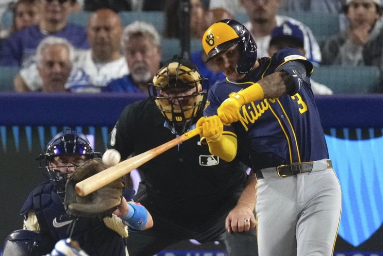 Joey Ortiz, de los Cerveceros de Milwaukee, derecha, conecta un jonrón solitario mientras el cácher de los Dodgers de Los Ángeles, Will Smith, observa durante la octava entrada de un partido de béisbol el sábado 19 de julio de 2025, en Los Ángeles. (AP Photo/Mark J. Terrill)