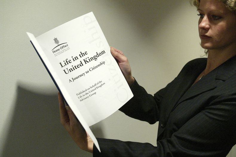 ARCHIVO – Una mujer sostiene una copia del libro “La vida en el Reino Unido”, que sirve como ayuda para aprobar el examen para obtener la ciudadanía británica, en el Museo Británico en el centro de Londres, el 31 de octubre de 2005. (AP Foto/Sergio Dionisio, Archivo)