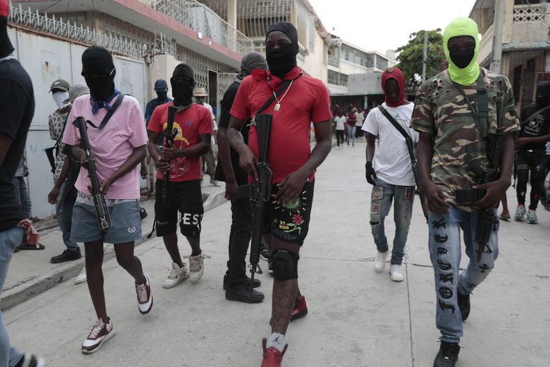 Miembros armados de la pandilla G9 y Familia participan en una marcha contra el primer ministro de Haití, Ariel Henry, en Puerto Príncipe, Haití, el 19 de septiembre de 2023. (AP Foto/Odelyn Joseph)