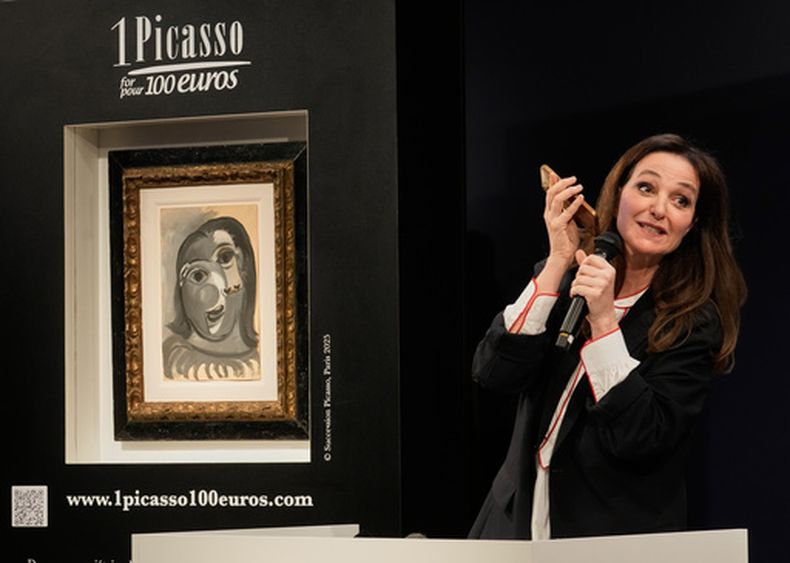 Peri Cochin, a la derecha, fundadora de 1 Picasso por 100 euros, junto a la obra Cabeza de una Mujer de Pablo Picasso, durante una rifa en la casa de subastas Christies, el martes 14 de abril de 2026, en París. (AP Foto/Michel Euler)