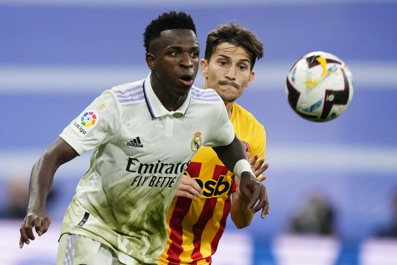 ARCHIVO - Vinicius Junior (izquierda) del Real Madrid es perseguido por Toni Villa de Girona durante el partido de la Liga de España, el domingo 30 de octubre de 2022, en el estadio Santiago Bernabéu. (AP Foto/José Bretón)