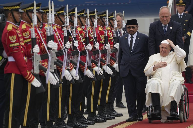 El Papa Francisco es recibido por el ministro de Asuntos Religiosos de Indonesia, Yaqut Cholil Qoumas, en el centro, poco después de aterrizar en el aeropuerto internacional Soekarno Hatta de Yakarta, el martes 3 de septiembre de 2024. (AP Foto/Gregorio Borgia)