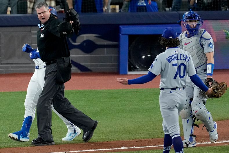 El umpire del plato Jordan Baker hace una advertencia a Justin Wrobleski, pitcher de los Dodgers de Los Ángeles, quien propinó un pelotazo al venezolano Andrés Giménez, de los Azulejos de Toronto, en el séptimo duelo de la Serie Mundial, el sábado 1 de noviembre de 2025 (AP Photo/Ashley Landis)